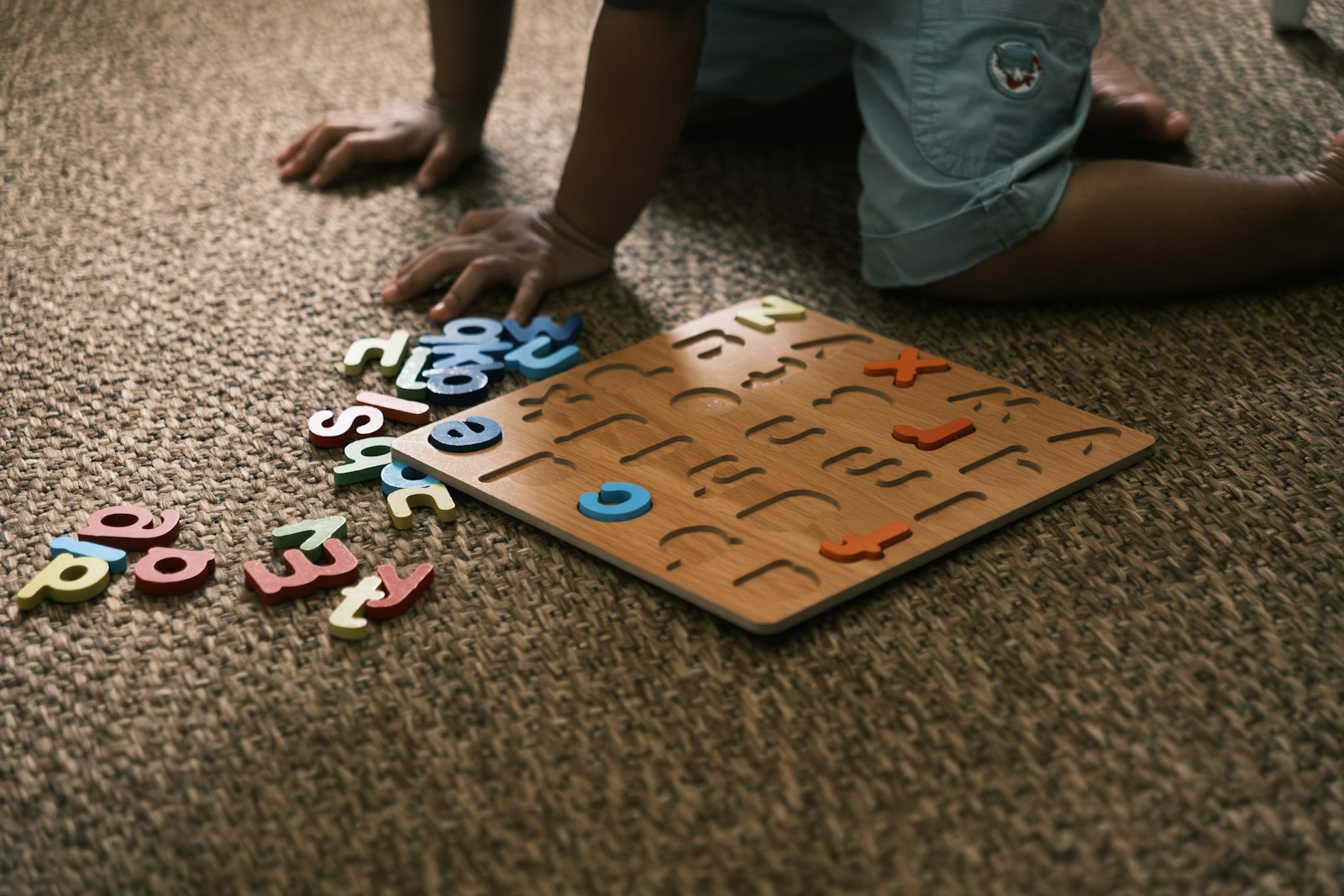 Child engaged with a colourful alphabet puzzle, exploring early learning