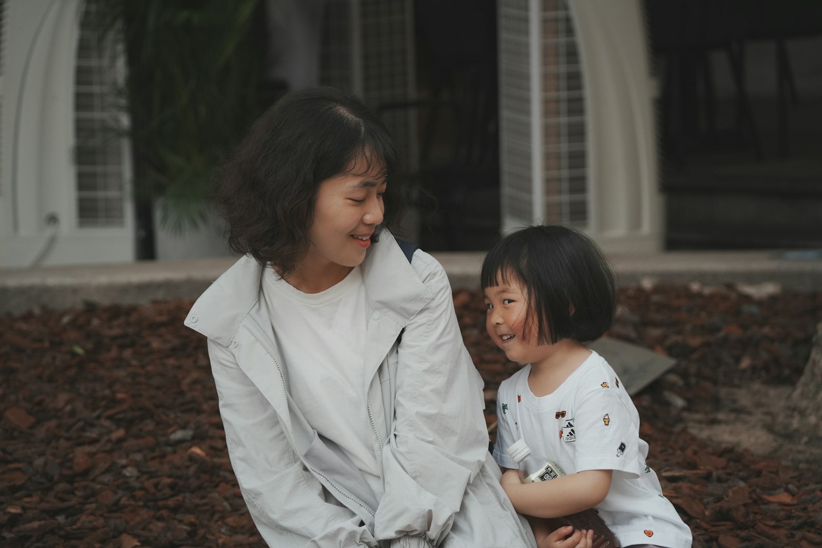 Adult sitting tenderly beside a young child in a supportive moment