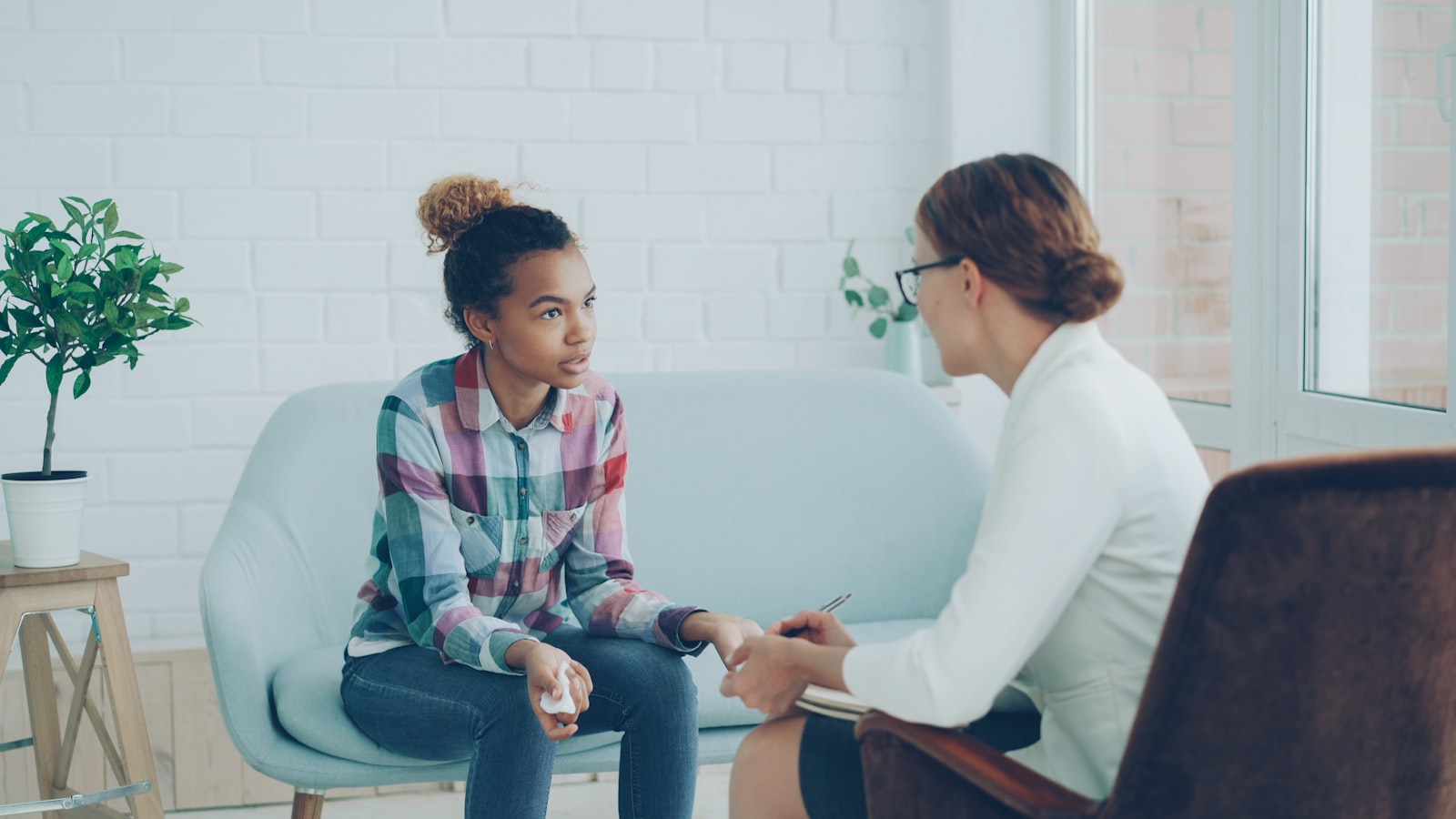 Therapist listening attentively to a young person during a counselling session