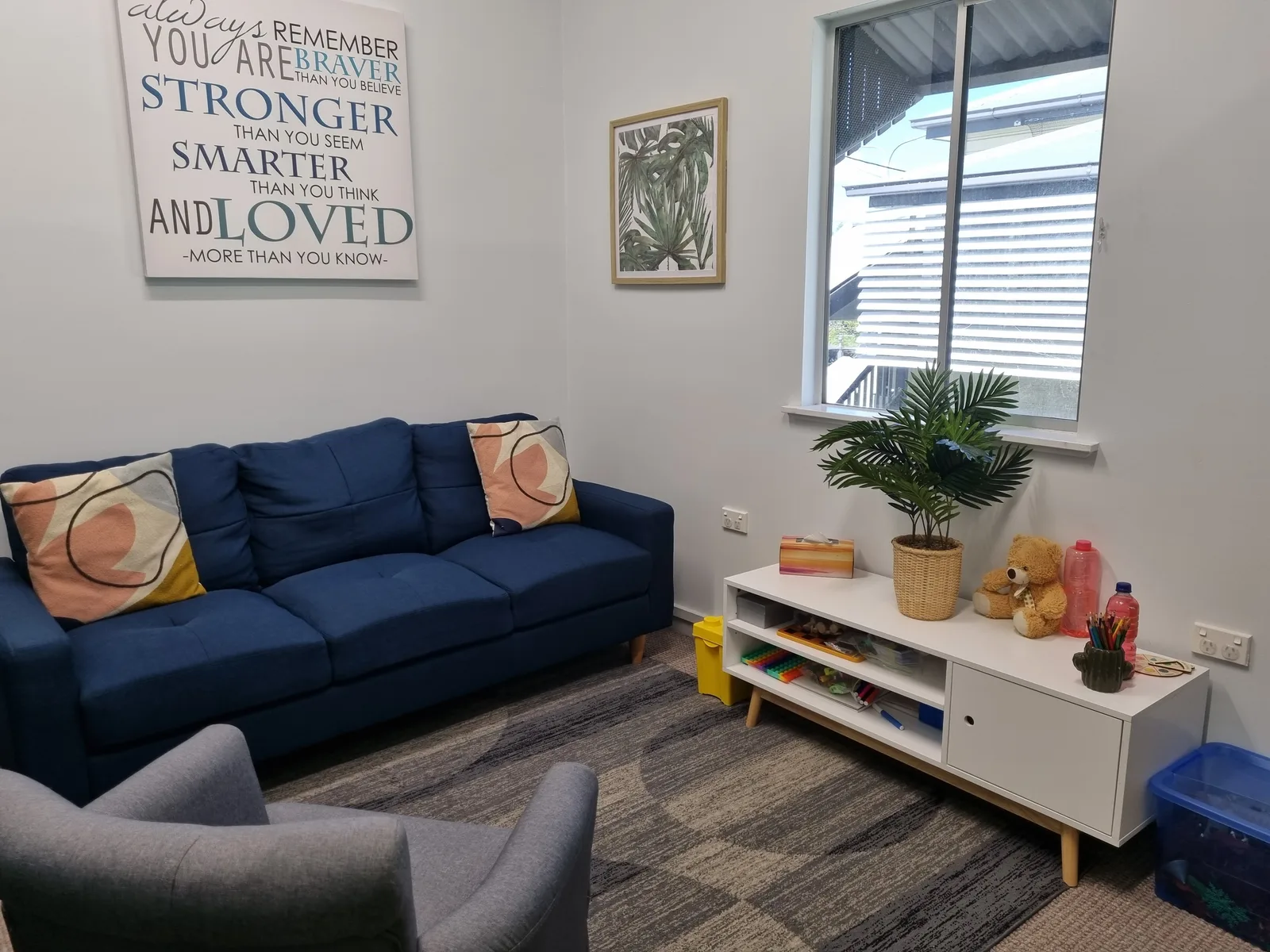 Welcoming therapy room at Caterpillar Clinic in Cairns with a blue couch and children's play area
